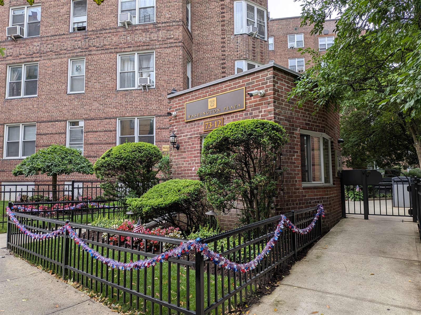 The landscaped Washington Plaza entrance at 73-12 35th Avenue